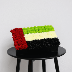 Rectangular UAE Flag Flower Arrangement box with red roses, green chrysanthemums, white flowers, and black flowers for National Day corporate display.